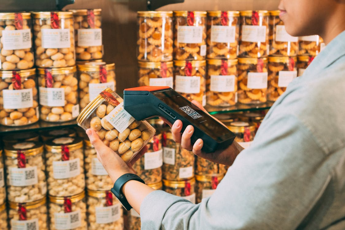 Worker scanning a product label, illustrating barcode technology in retail inventory.