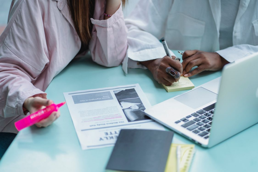 People reviewing printed research, illustrating how to compare claims using evidence and notes.