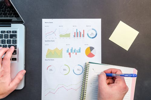 Charts and notes on a desk, illustrating how to read statistics without being misled by data presentation.