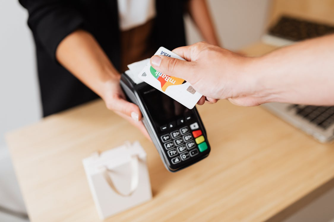Customer tapping a card reader, illustrating how credit card processing works during checkout.