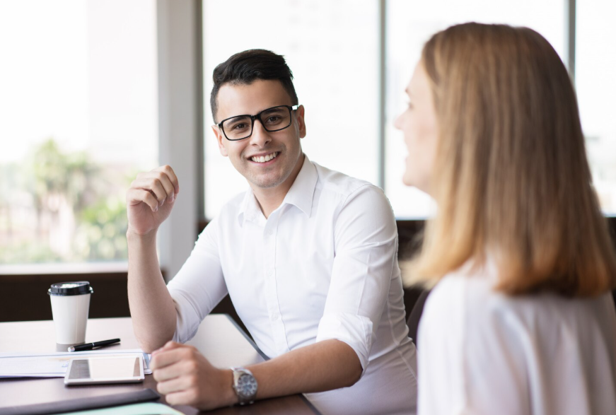 Two professionals having a conversation, illustrating the psychology of first impressions through facial expression.