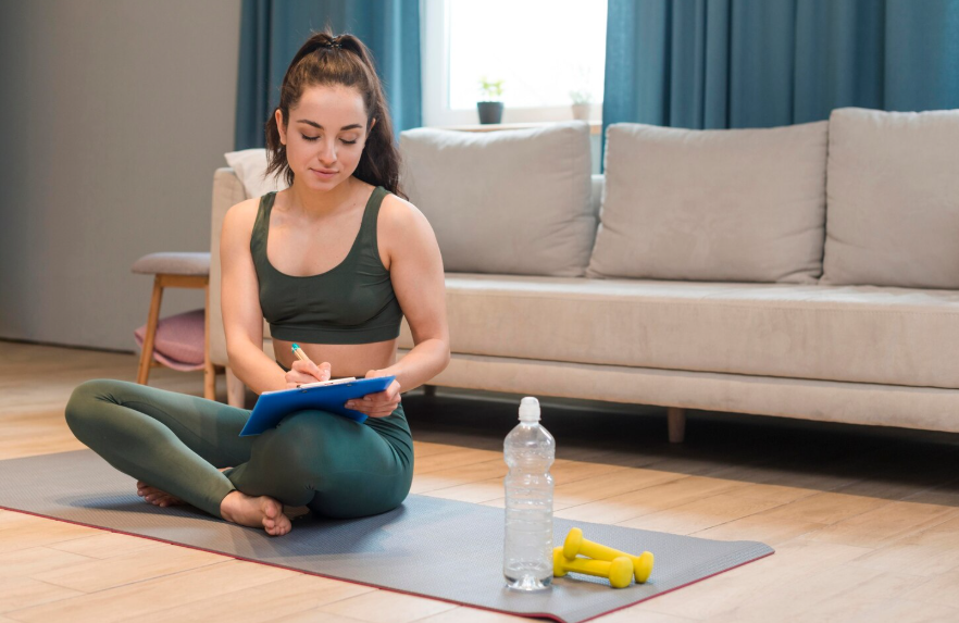 Woman writing in a habit tracker, illustrating how to build better habits through small routines.