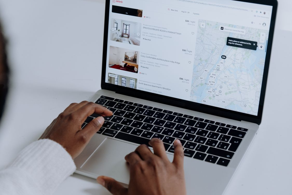 Person comparing lodging prices online, illustrating dynamic pricing in travel and rentals.
