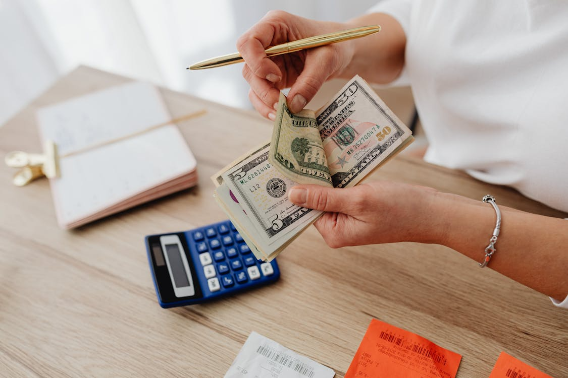 Person reviewing cash and receipts, illustrating opportunity cost examples in everyday spending.