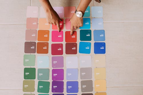 Hands selecting color swatches, illustrating color meanings in branding.