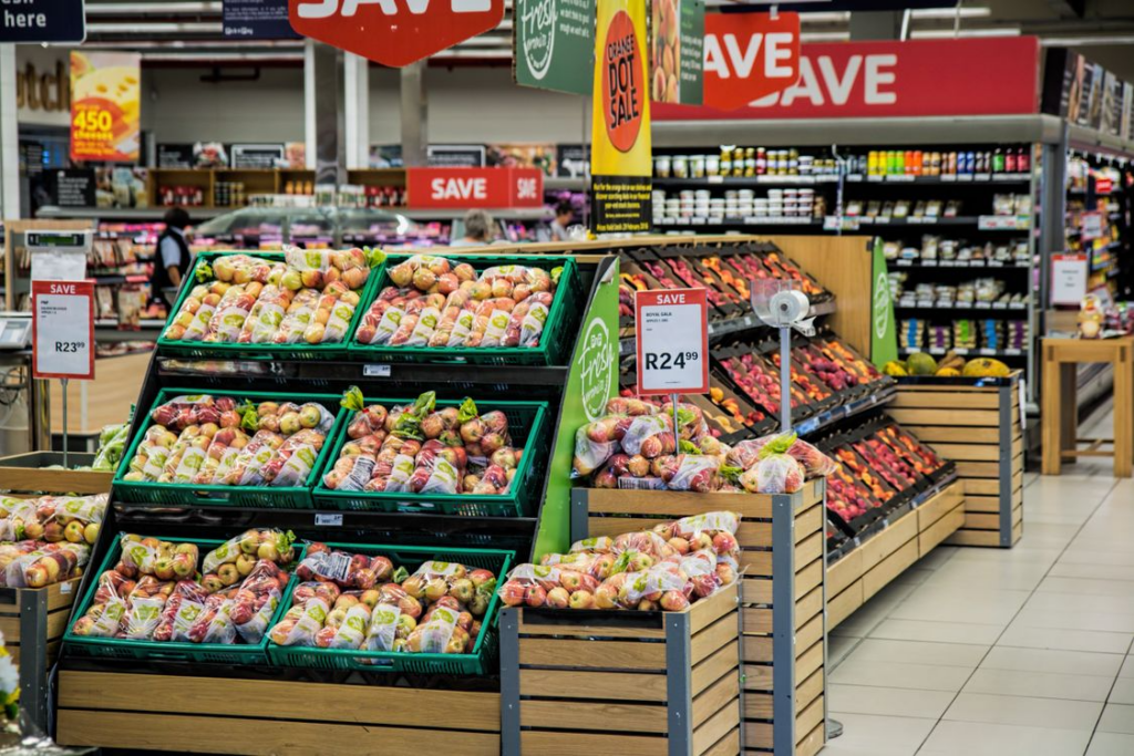 Grocery produce section with sale signs, illustrating grocery store layout and product placement.