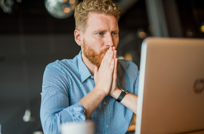 Worried person looking at a laptop, illustrating why people overestimate risks after seeing alarming information online.